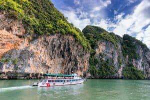 people on ship traveling on water beside land